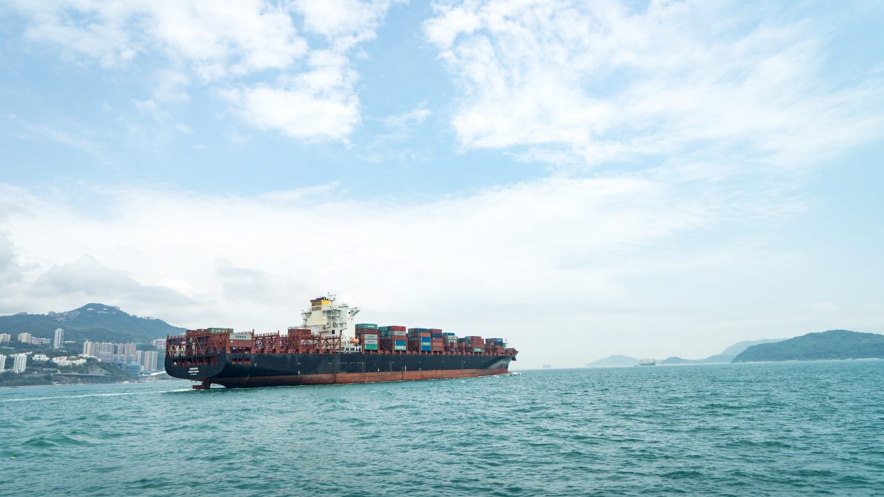 Fracht Morski. Kontenerowiec wypływający z portu w Hong Kongu w kierunku Europy.